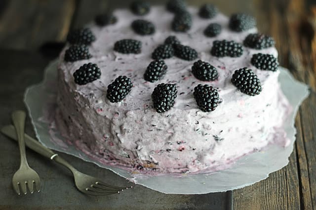 blackberry lime cake on baking sheet with criss crossed forks.