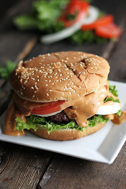 burger on small white square plate.