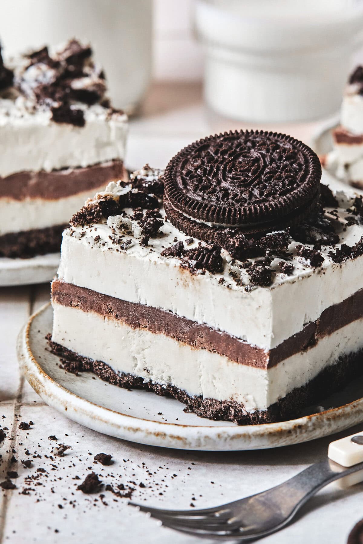 A slice of no bake Oreo ice cream dessert on a plate.