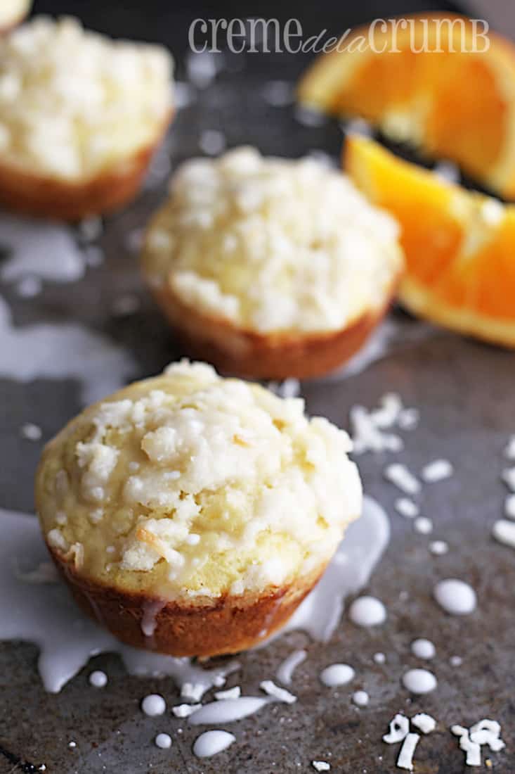 muffins and slices of an orange on a baking sheet.