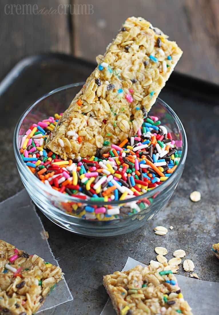 granola bar dipped in bowl of sprinkles.