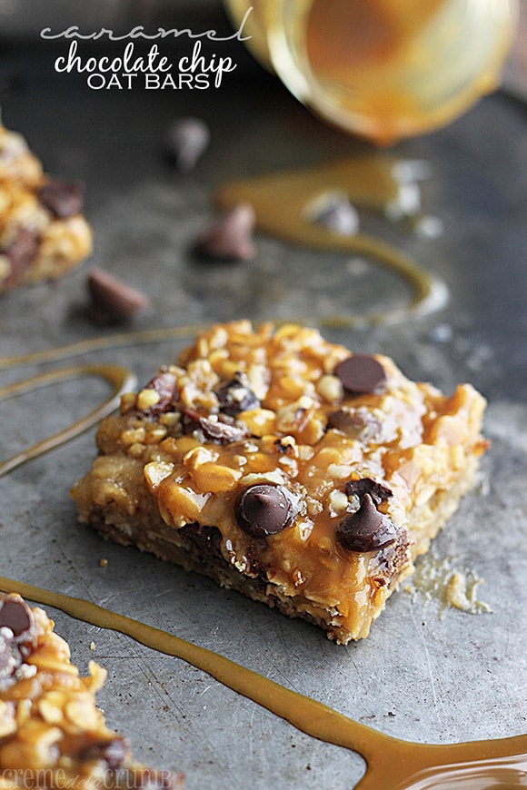 caramel chocolate chip oat bar on a baking sheet with caramel drizzled across with the title written on the top left corner of image.