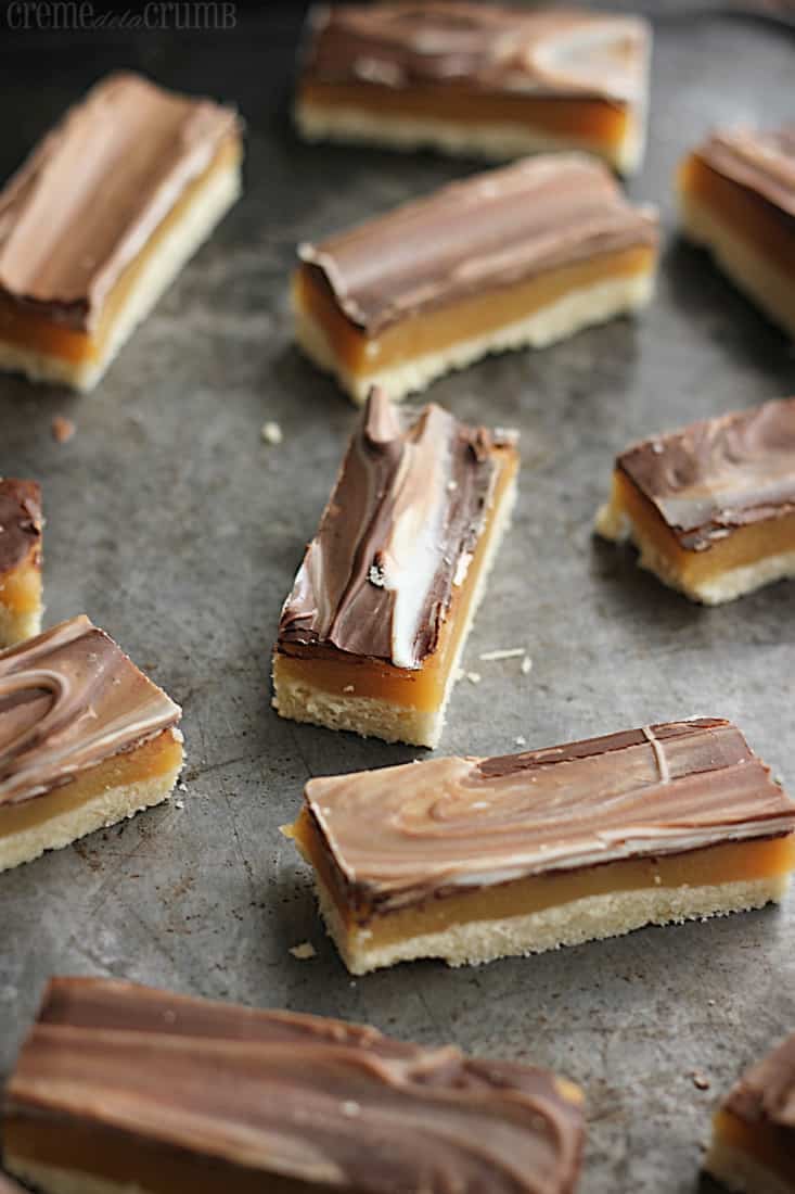 chocolate caramel shortbread bars on a baking sheet.