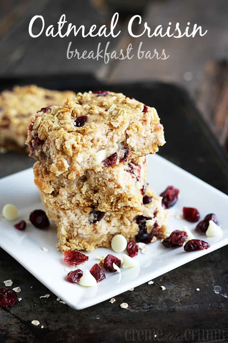 stacked breakfast bars on a plate with Craisins and white chocolate chips with the title written on the top of the image.