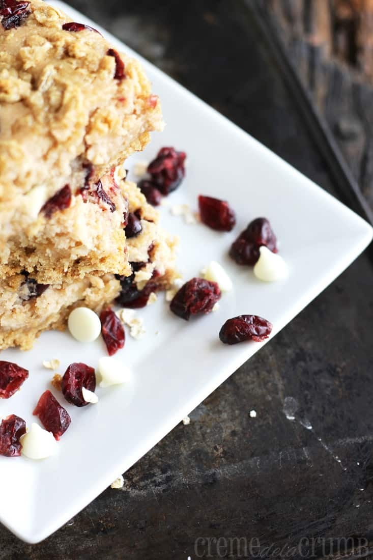 Craisins and white chocolate chips with stacked breakfast bars on a plate.