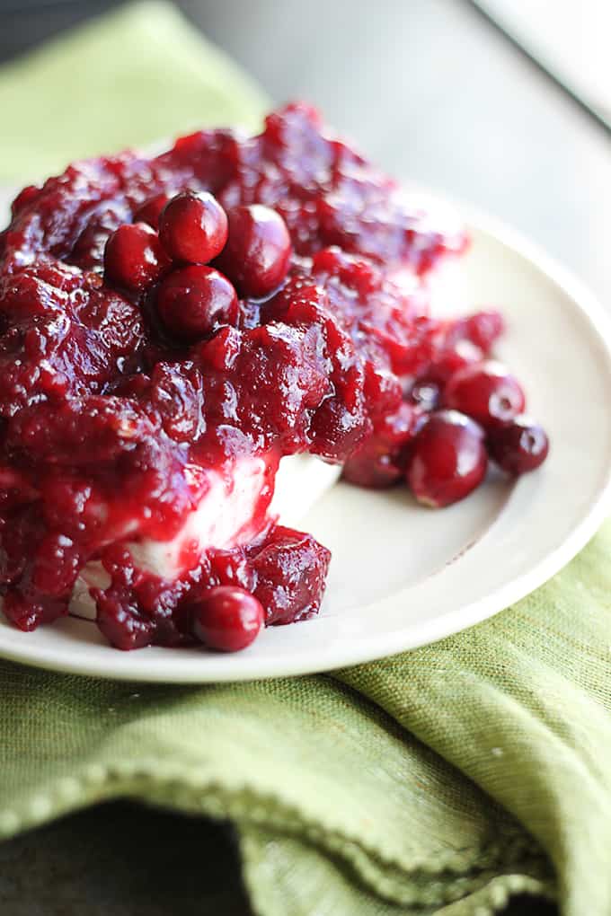 chipotle cranberry cream cheese dip on a plate on a green cloth napkin.