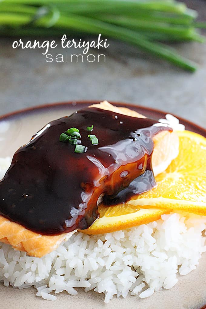 orange teriyaki salmon on orange slices on rice on a plate with the title written on the top left of the image.