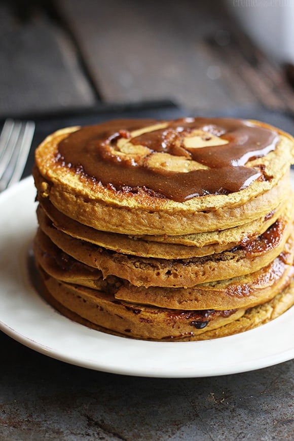 pumpkin cinnamon roll pancakes without cream cheese vanilla glaze on a plate. 