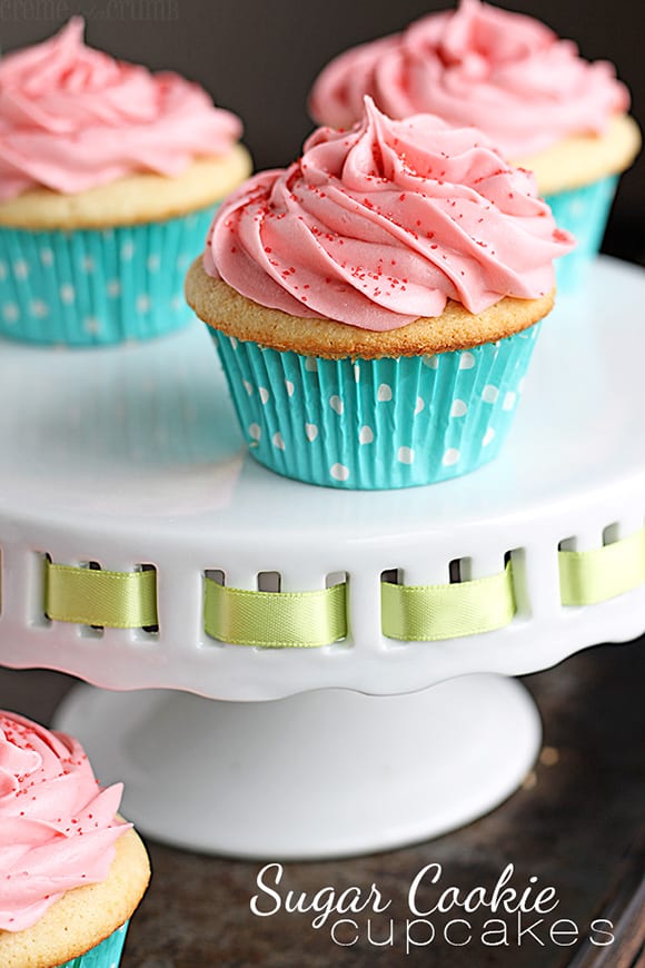 sugar cookie cupcakes on a cake platter with the title of the recipe written on the bottom right corner of the image.