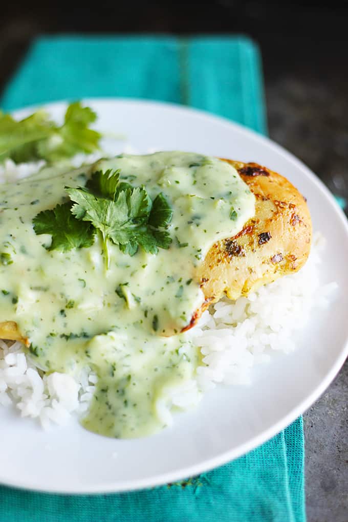 tomatillo ranch chicken on rice on a plate on top of a blue cloth napkin.