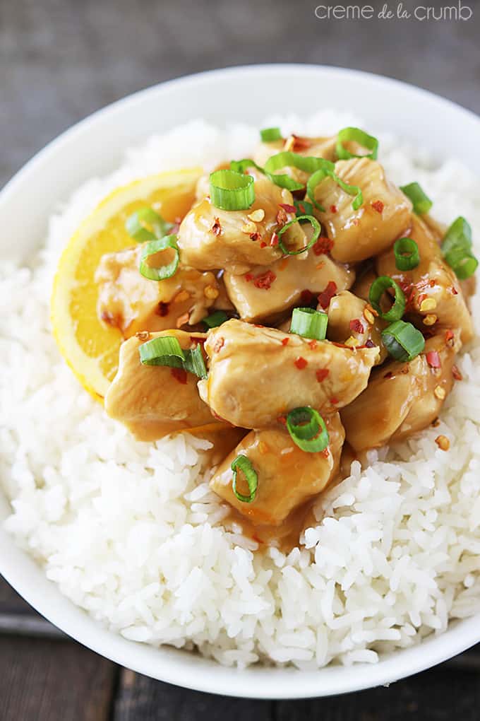 top view of baked orange chicken on rice in a bowl.