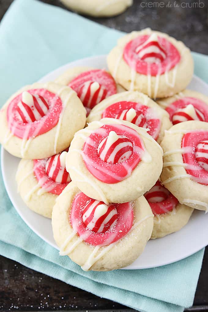top view of peppermint Kiss thumbprint cookies on a plate on a cloth napkin.