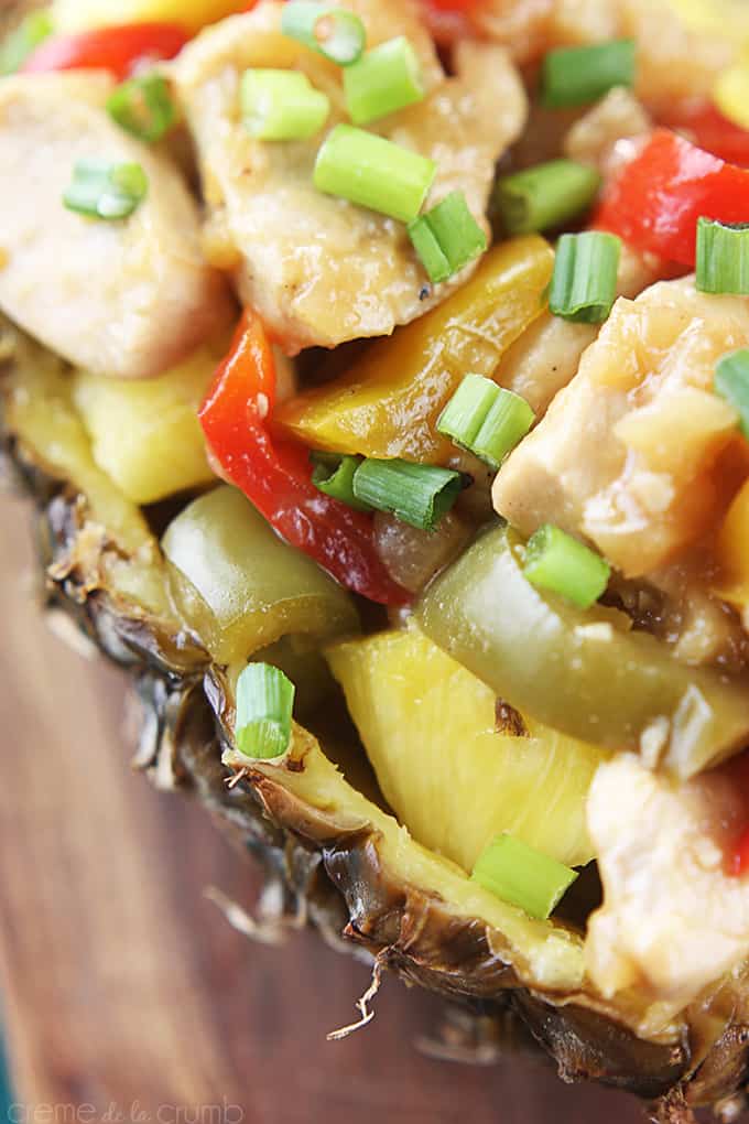 up close view of pineapple chicken in a hallowed pineapple half.