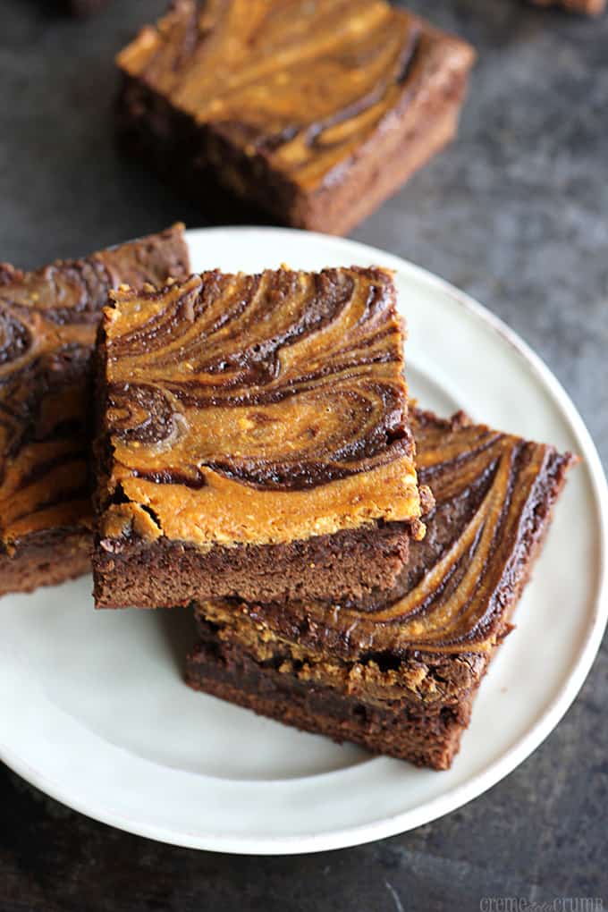 pumpkin swirl brownies on a plate with more brownies in the background.