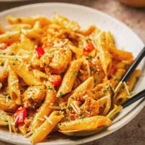 Close up of creamy Cajun shrimp pasta and a fork on a plate.