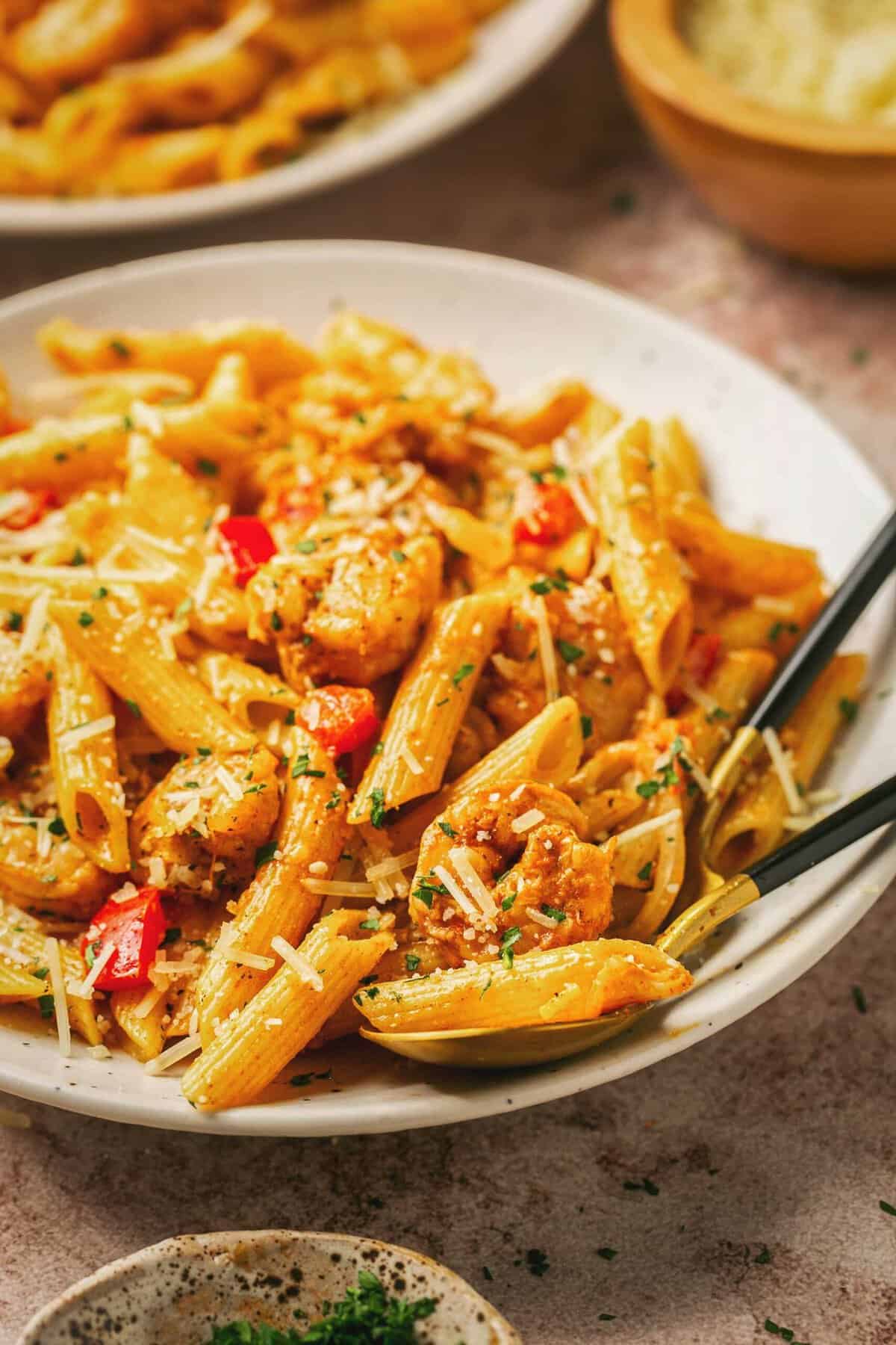 Close up of creamy Cajun shrimp pasta and a fork on a plate.