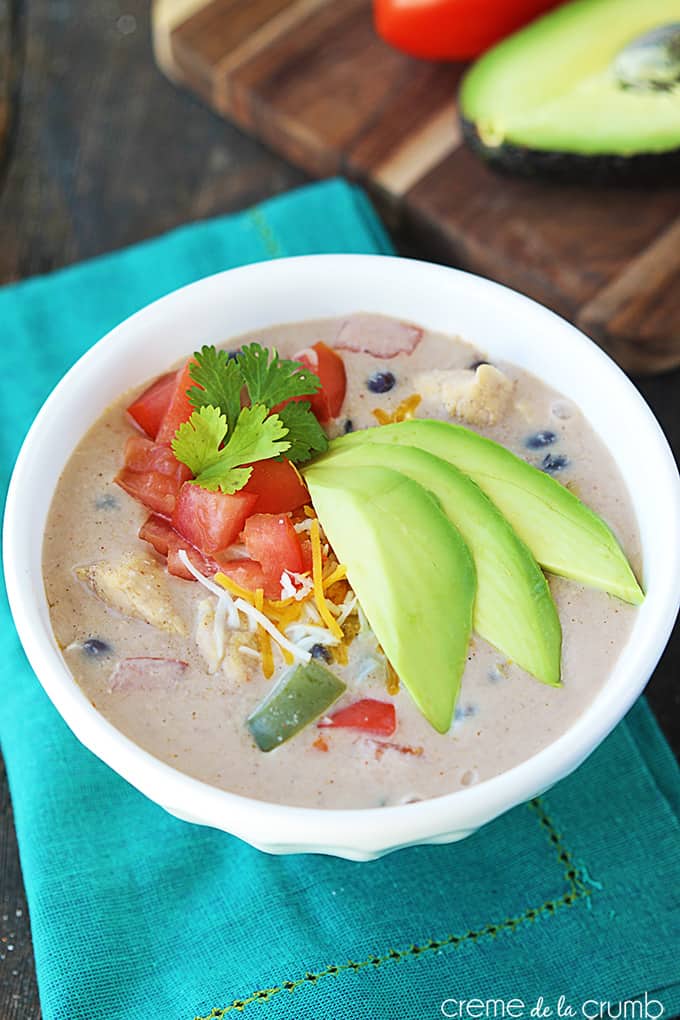 top view of chicken fajita soup in a bowl on a blue cloth napkin.