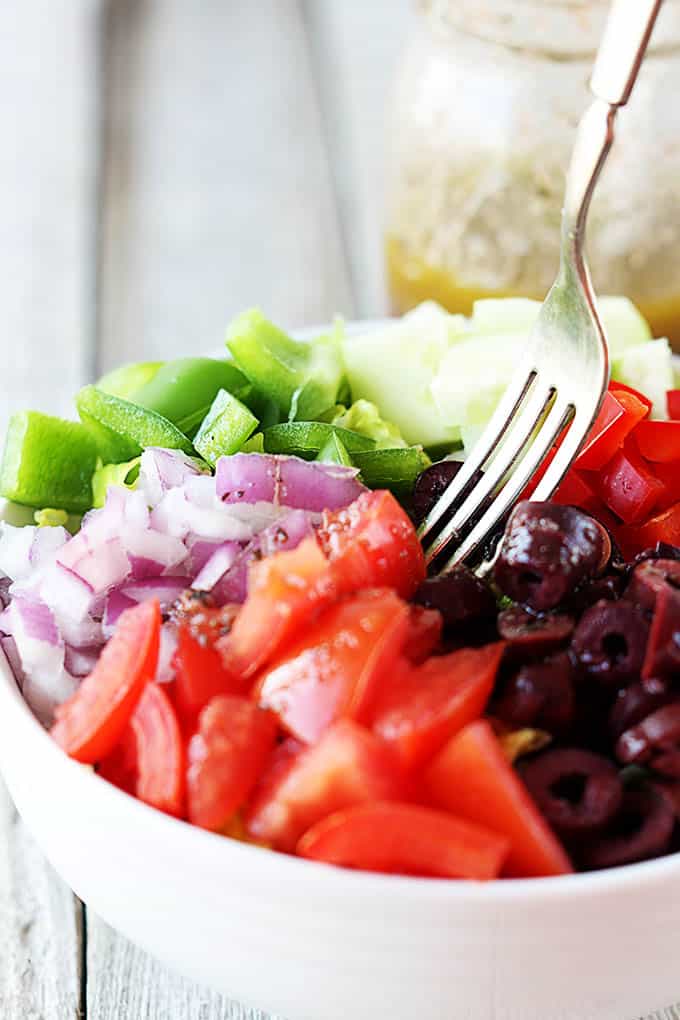 Greek chopped salad in a bowl with a fork.