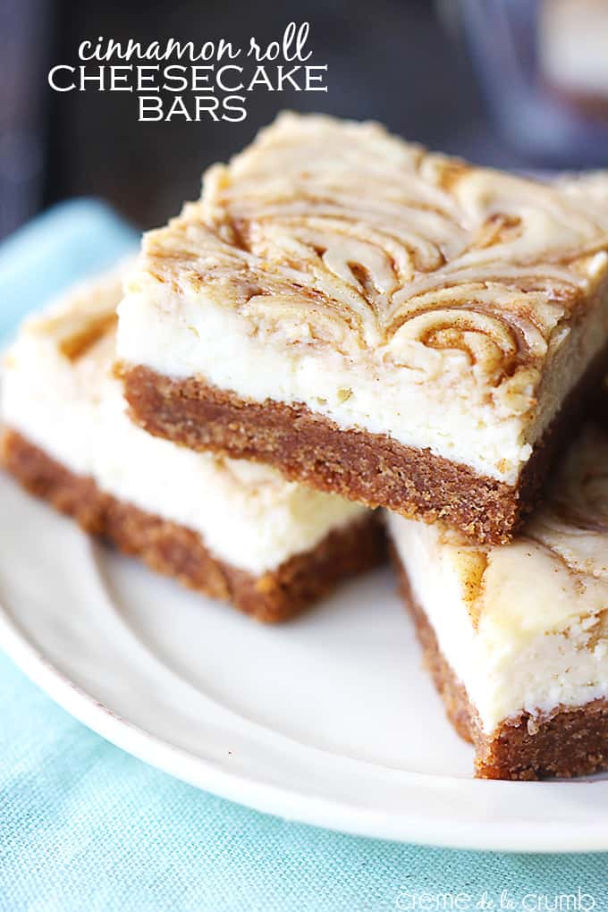 cinnamon roll cheesecake bars on a plate with the title of the recipe written on the top left corner of the image.