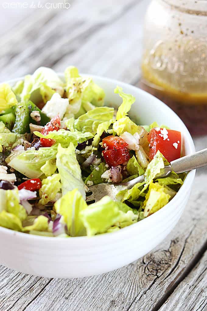 Greek chopped salad tossed in a bowl with a fork.