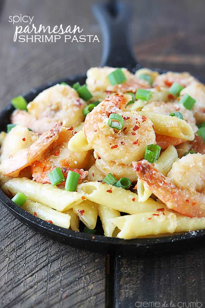 spicy parmesan shrimp pasta in a skillet with the title of the recipe written on the top left corner of the image.