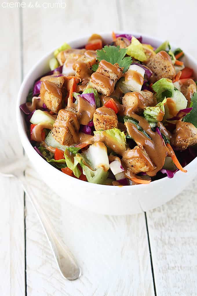 top view of Thai chicken chopped salad in a bowl with dressing on top.