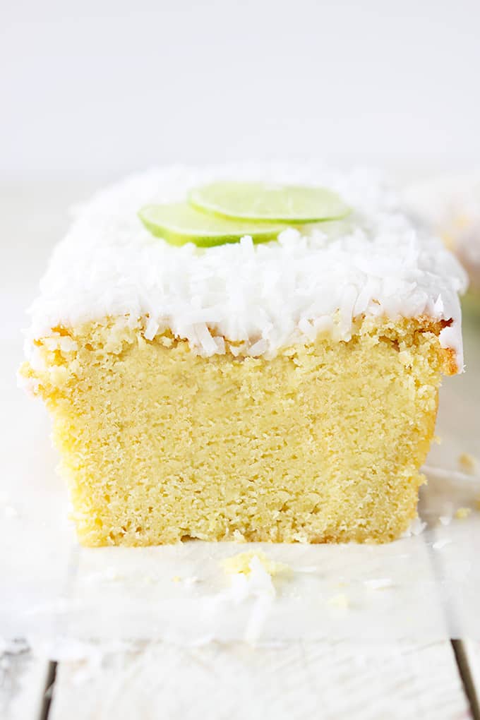 coconut lime pound cake topped with coconut lime glaze and slices of lime.