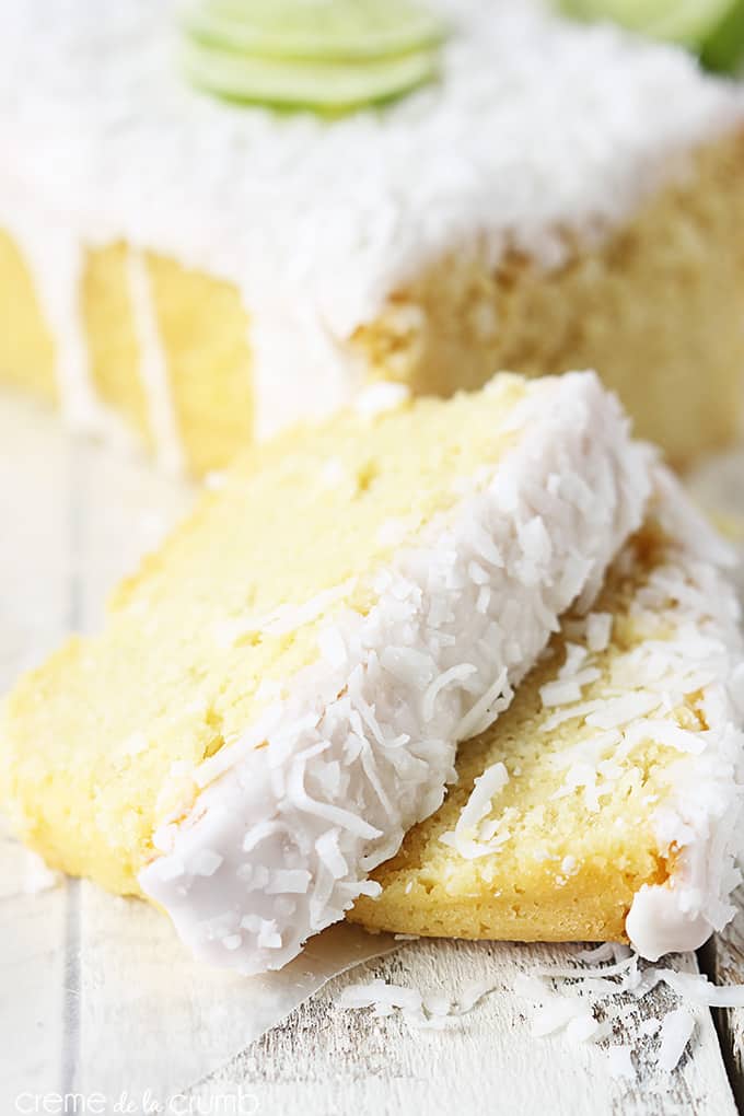 slices of coconut lime pound cake topped with coconut lime glaze with the rest of the pound cakes faded in the background.