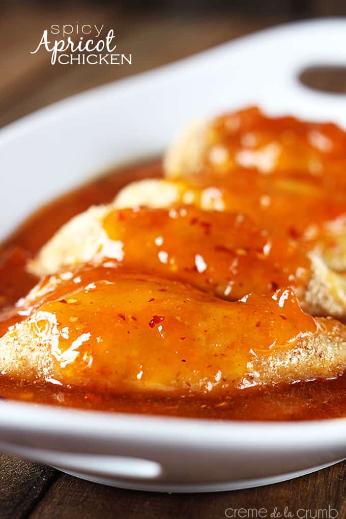 spicy apricot chicken topped with sweet and spicy apricot sauce on a serving tray with the title of the recipe written on the top left corner of the image.