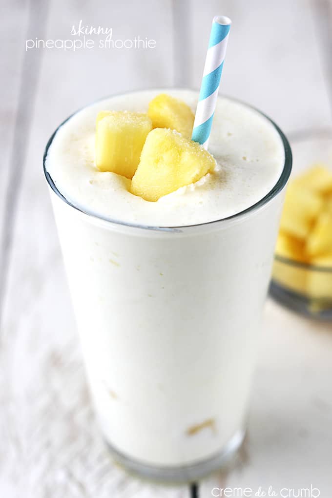 skinny pineapple smoothie in a glass with pineapple chunks and a straw with the title of the recipe written on the top left corner of the image.