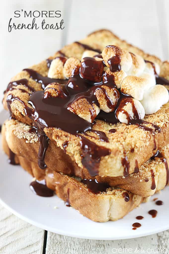 S'mores French toast on a plate topped with marshmallows and chocolate syrup with the title of the recipe written on the top left corner of the image.