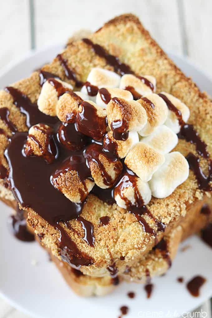 top view of S'mores French toast on a plate topped with marshmallows and chocolate syrup.