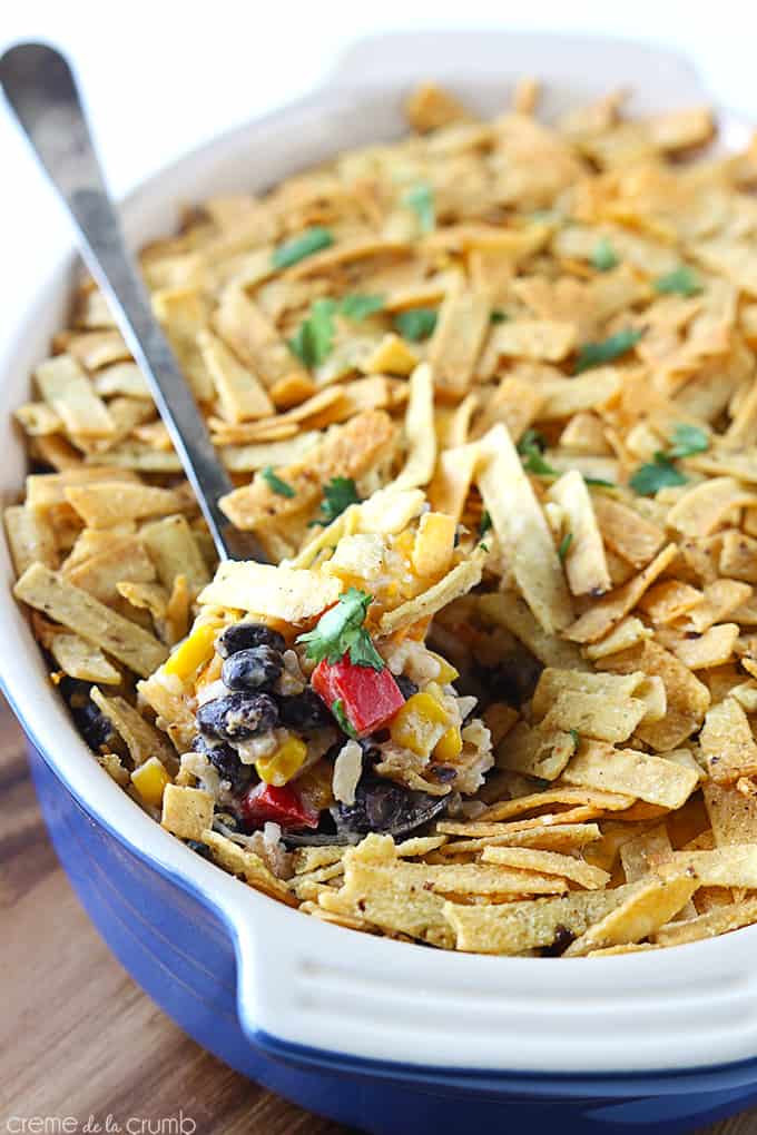 tex mex chicken bake in a serving tray with a spoon with a scoop of tex mex chicken bake.