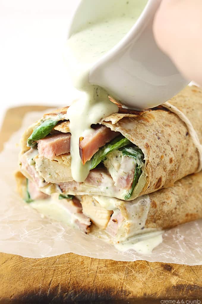 stacked chicken cordon bleu ranch wraps with homemade ranch being poured on top.