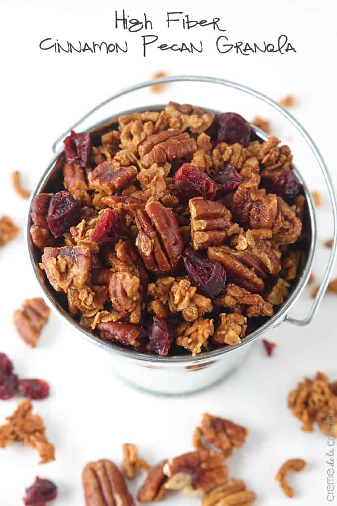 top view of cinnamon pecan granola in a metal bucket with the title of the recipe written on the top of the image.