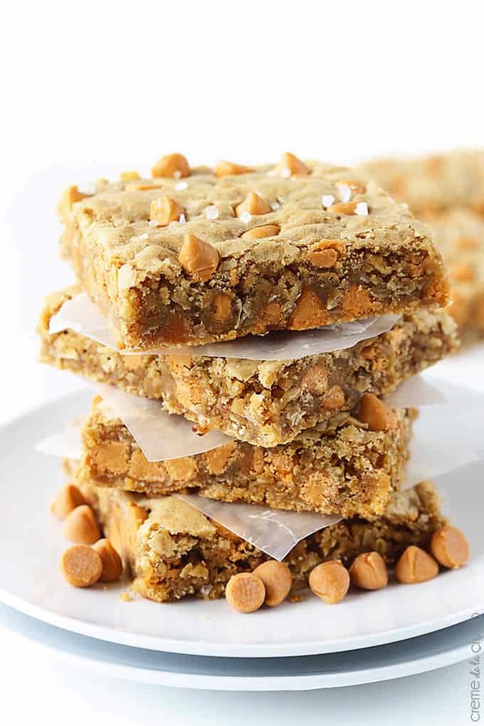 stacked oatmeal butterscotch blondies on a plate with butterscotch chips.