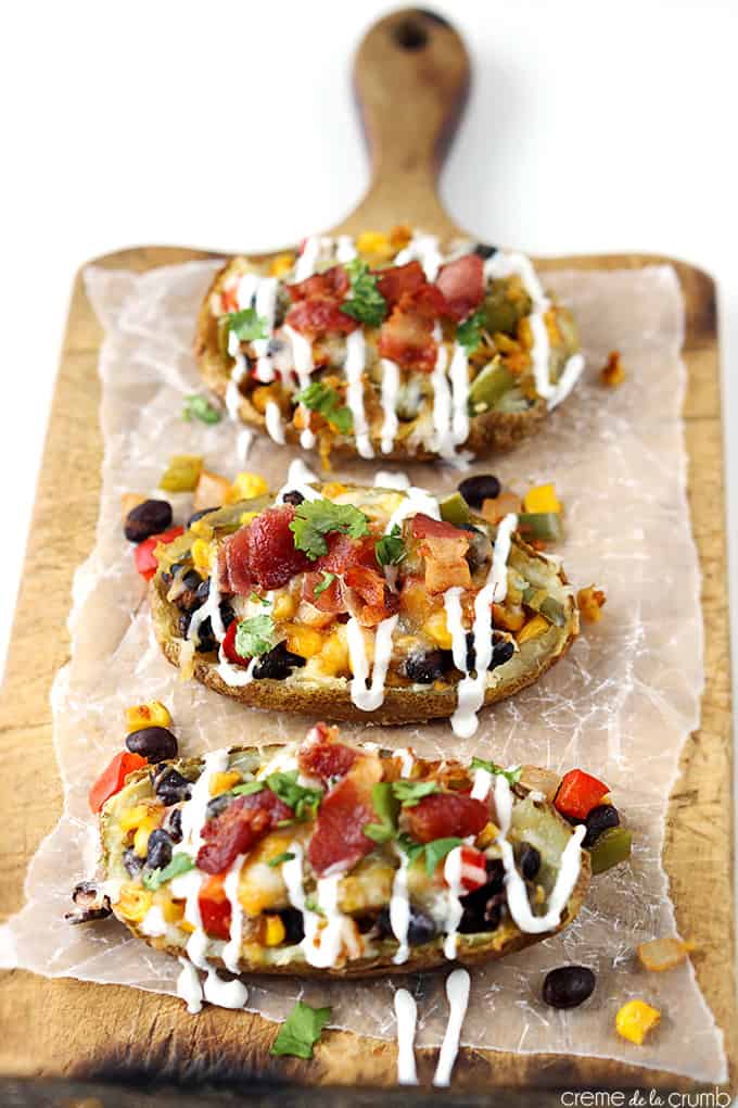 Southwest loaded potato skins on a wooden cutting board.