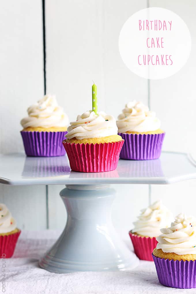 birthday cake cupcakes on a pedestal cake tray with a candle in one of the cupcakes with the title of the recipe written on the top right corner of the image.