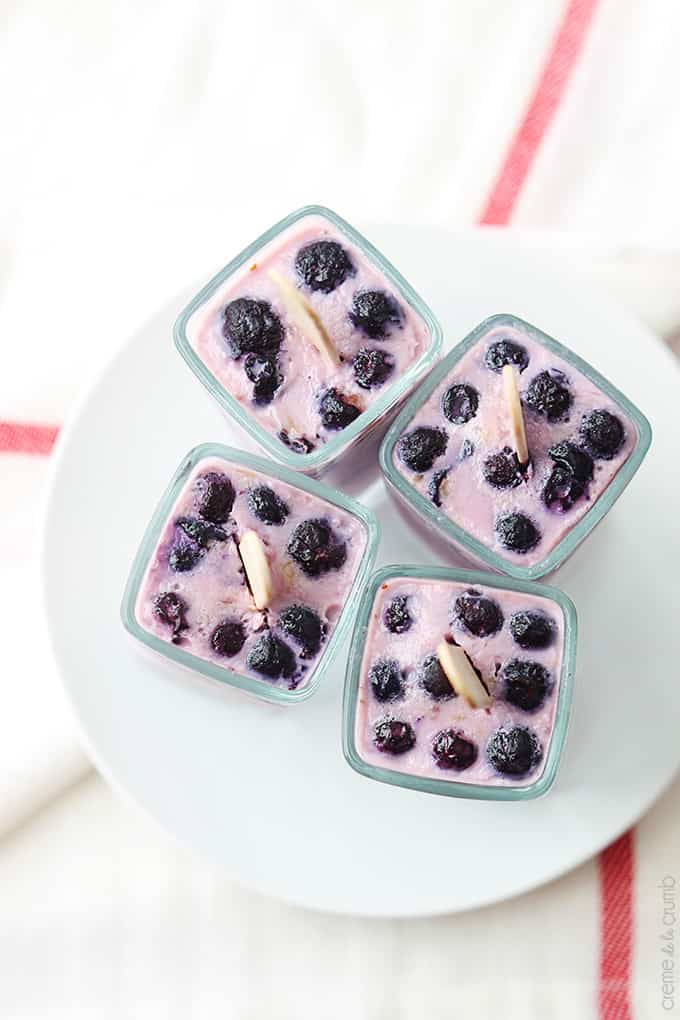 top view of blueberry Greek yogurt popsicles upside down in glasses on a plate. 