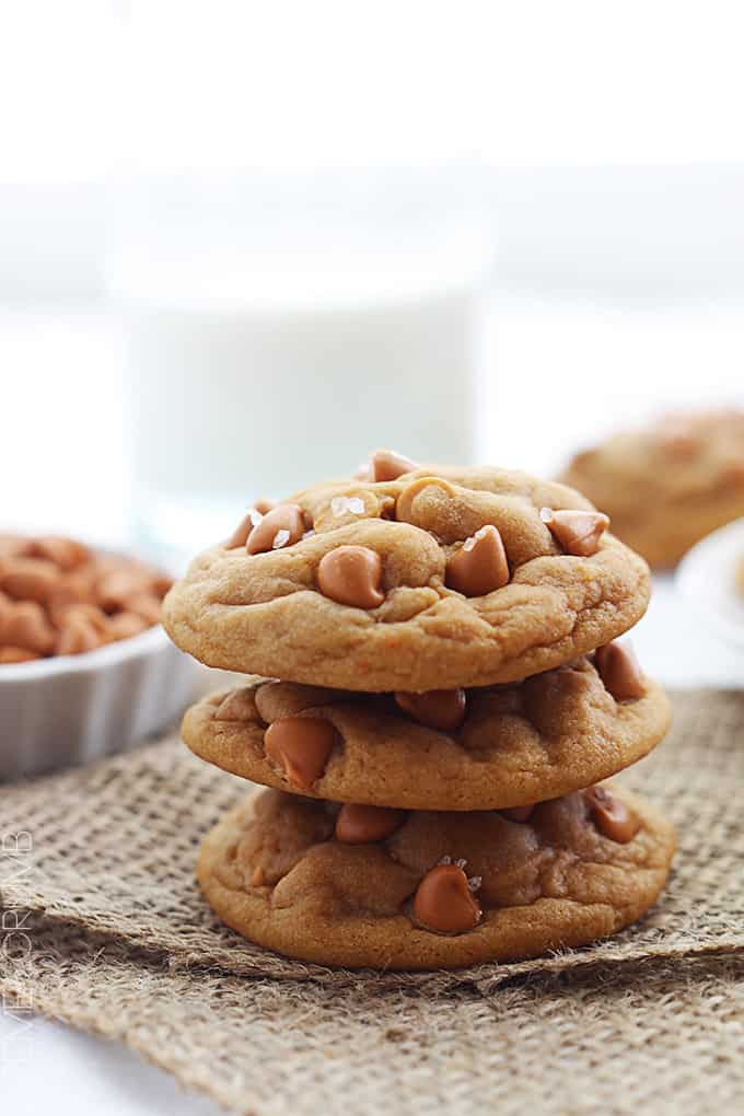 stacked butterscotch chip pudding cookies on a burlap table runner.