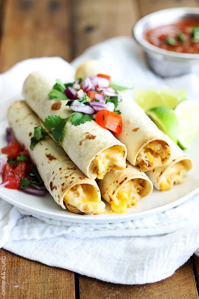 slow cooker cream cheese chicken taquitos on a plate on a white cloth napkin.