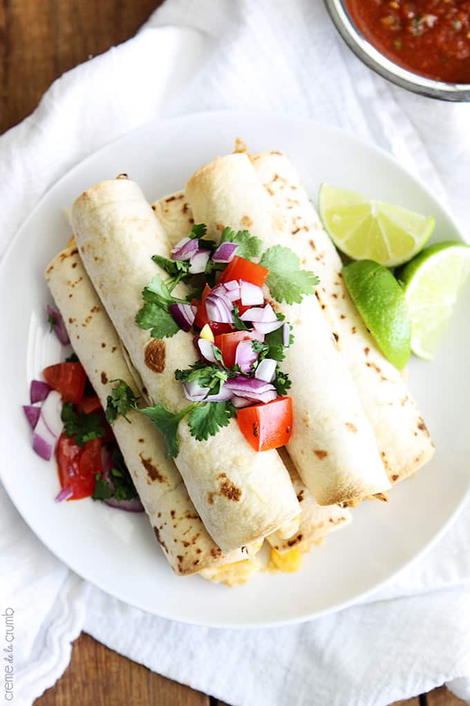 top view of slow cooker cream cheese chicken taquitos on a plate on a white clothe napkin.