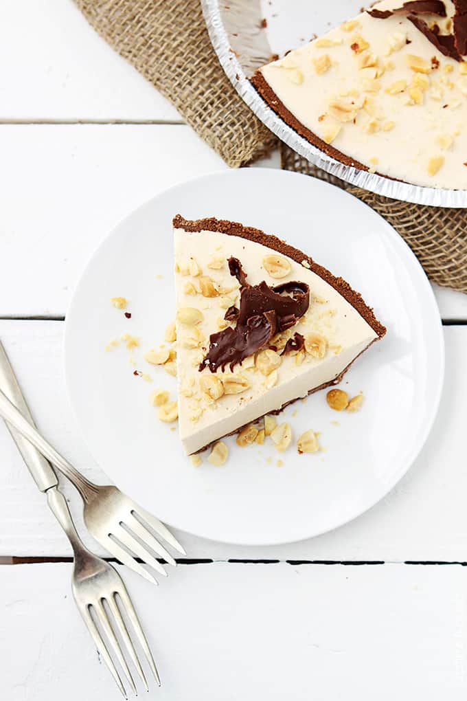 top view of a slice of frozen peanut butter pie on a plate with two forks on the table.