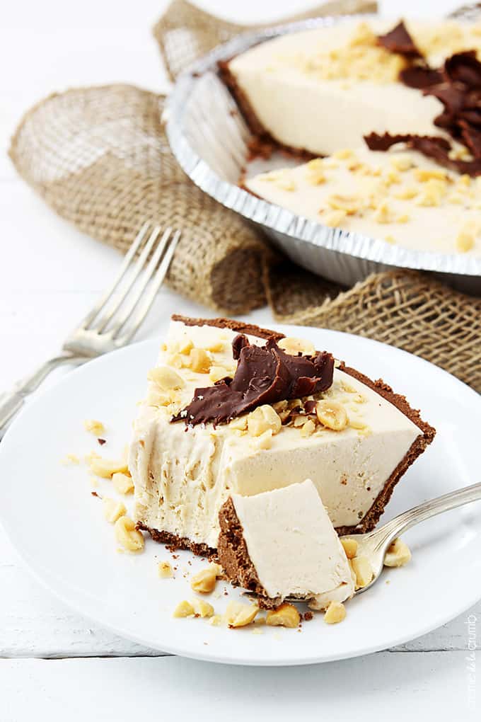 frozen peanut butter pie on a plate with a bite taken from it with a fork with the bite on it on the side.