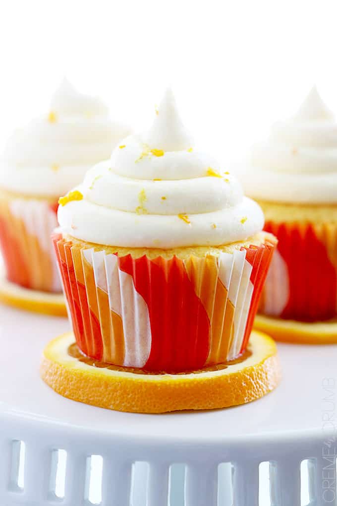 orange cream cupcakes on top of orange slices.