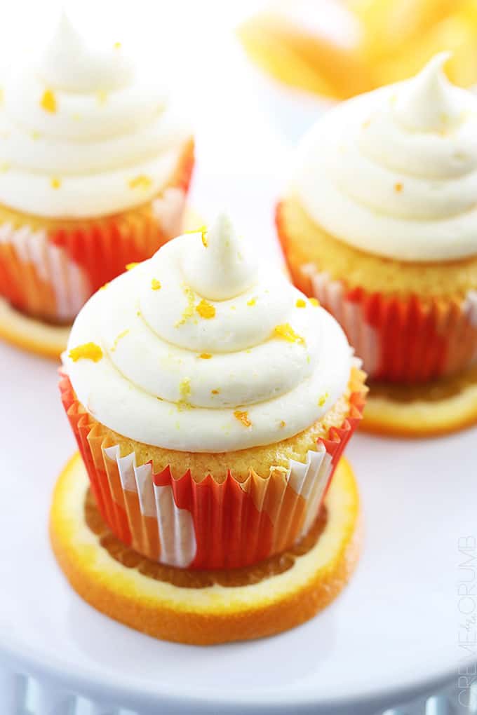 top view of orange cream cupcakes on top of orange slices.