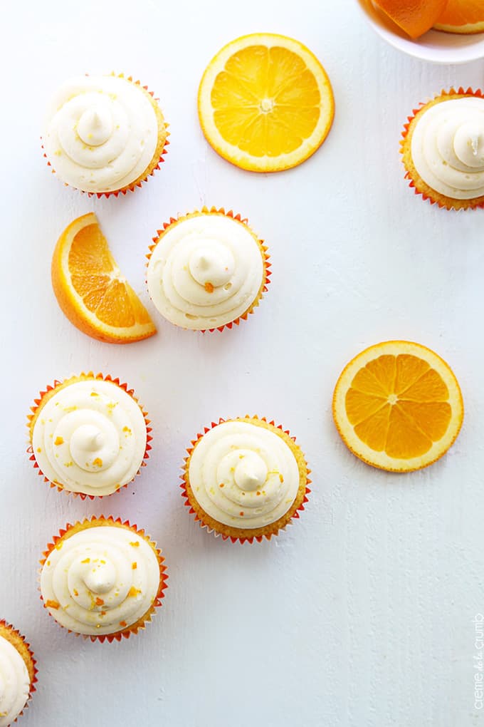 top view of orange cream cupcakes and orange slices.