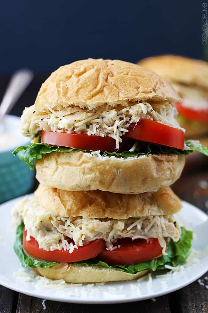 close up of two stacked slow cooker chicken caesar sliders on a plate.