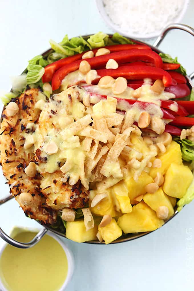 top view of a metal bowl of Pina Colada chicken salad with Pina Colada vinaigrette in bowls on the side. 