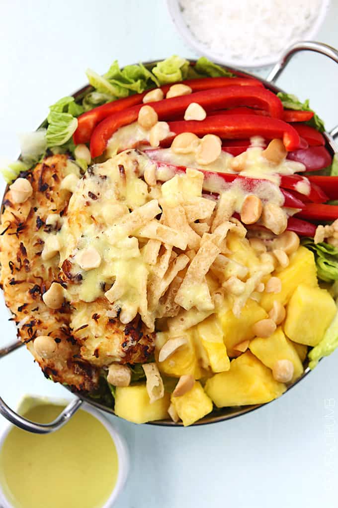 top view of a metal bowl of Pina Colada chicken salad with Pina Colada vinaigrette in bowls on the side.